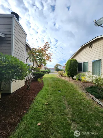a view of backyard of house with green space
