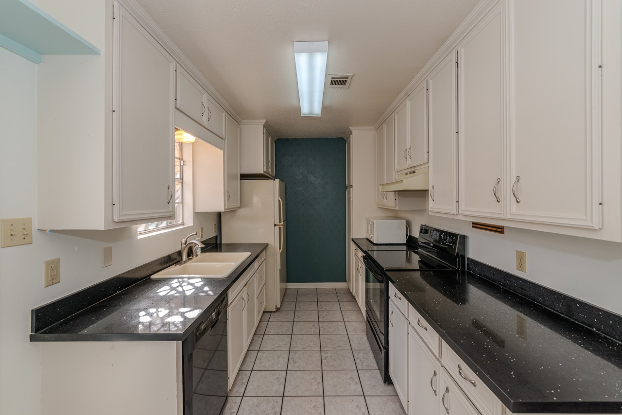 5975 Meadow Way Beaumont, TX 77707 - Photo 6 of 18 a kitchen with granite countertop a stove sink and cabinets
