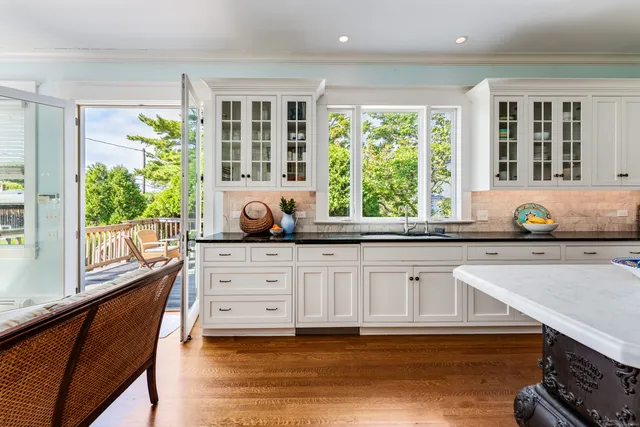 a kitchen with stainless steel appliances granite countertop a stove a sink and a granite counter tops with white cabinets