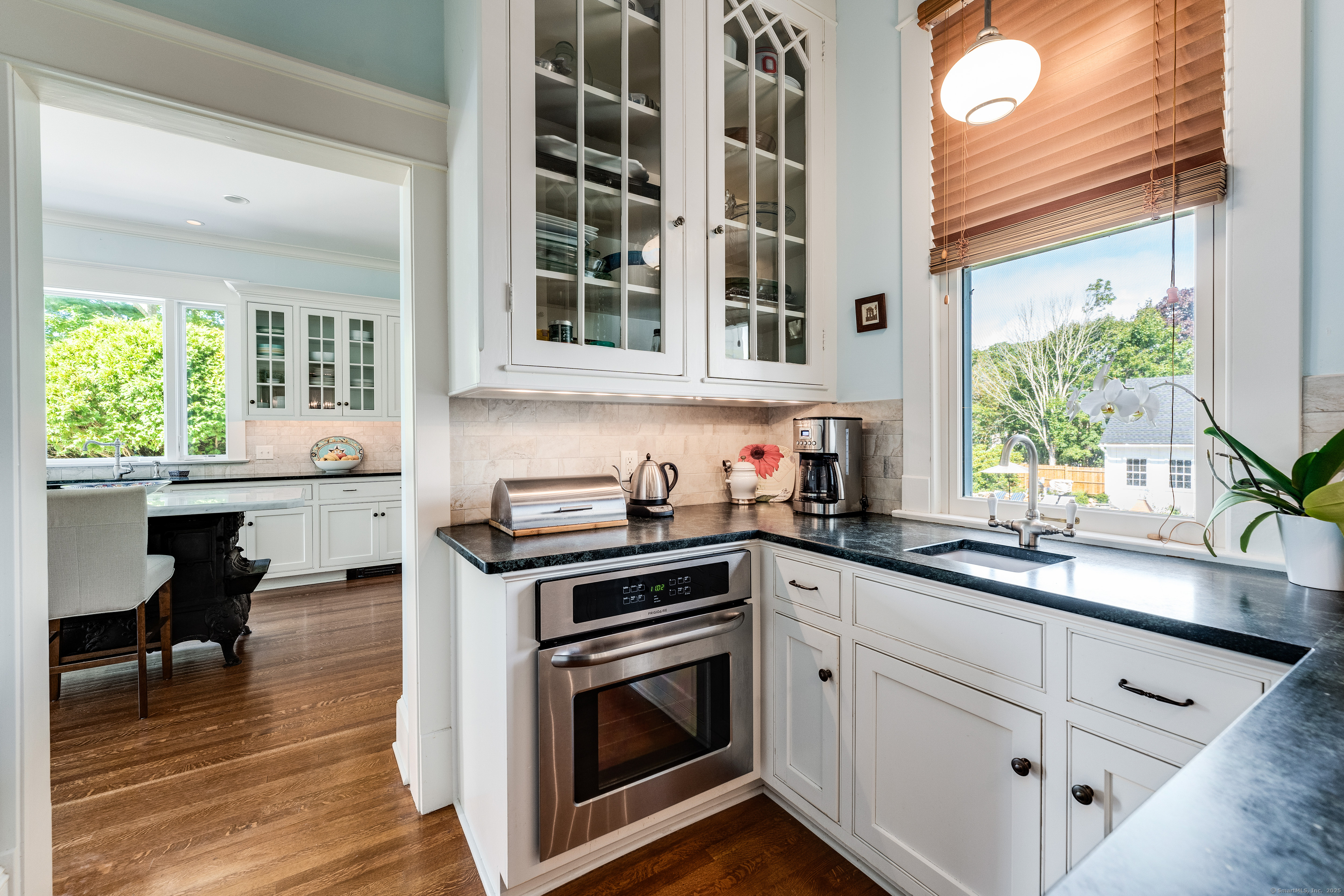 27 Church Street Groton, CT 06340 - Photo 16 of 37 a kitchen with stainless steel appliances a stove a sink and white cabinets with wooden floor