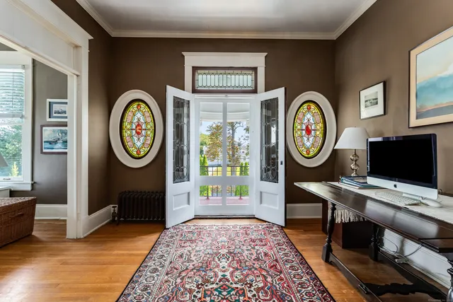 a view of a hallway with elevator with wooden floor