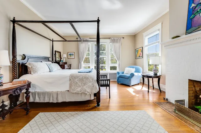 a bedroom with double bed a couch and a large window