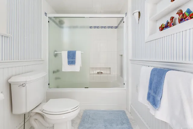 a bathroom with a shower a toilet and a sink