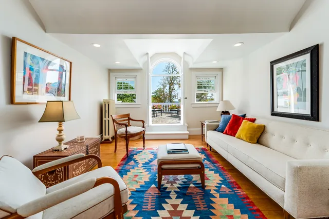 a living room with furniture fireplace and a large window