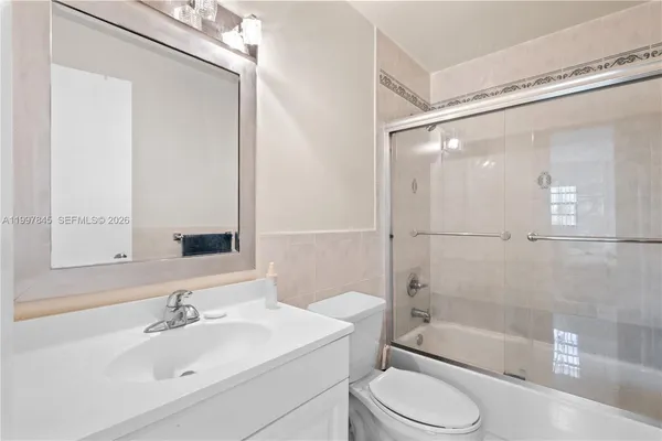 a bathroom with a sink mirror bathtub and toilet