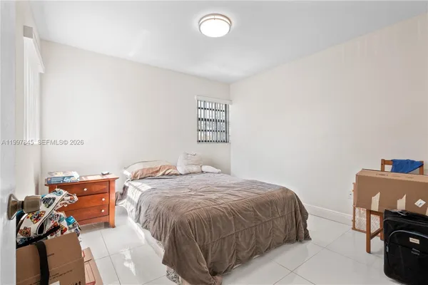 a bed sitting in a bedroom next to a window
