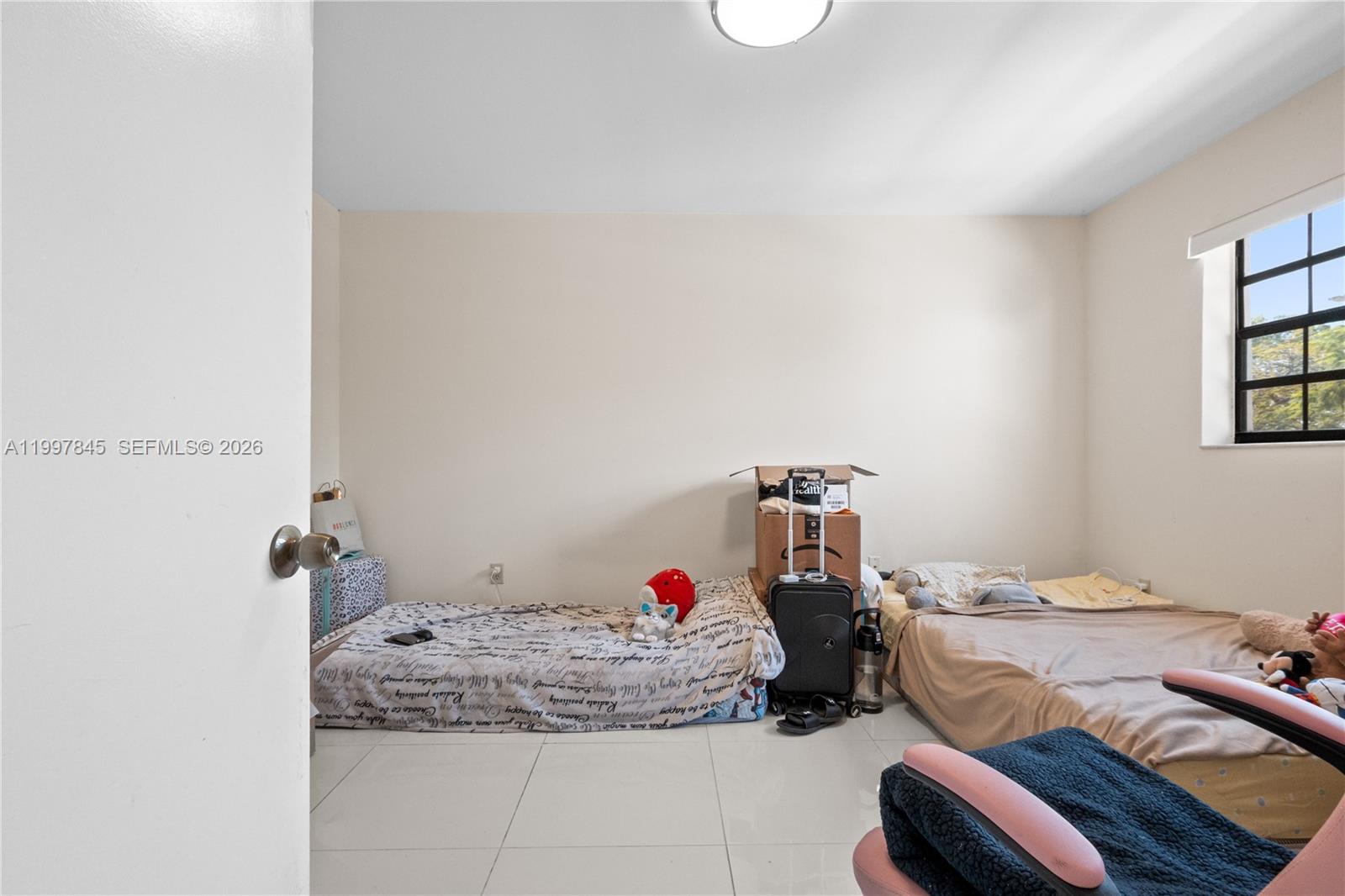 6211 Southwest 138th Court, Unit B Miami, FL 33183 - Photo 16 of 24 a bed room with a bed and a chandelier