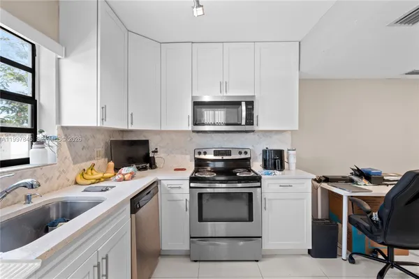 a kitchen with cabinets appliances and a sink