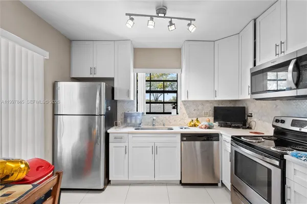 a kitchen with stainless steel appliances a stove a sink and a refrigerator