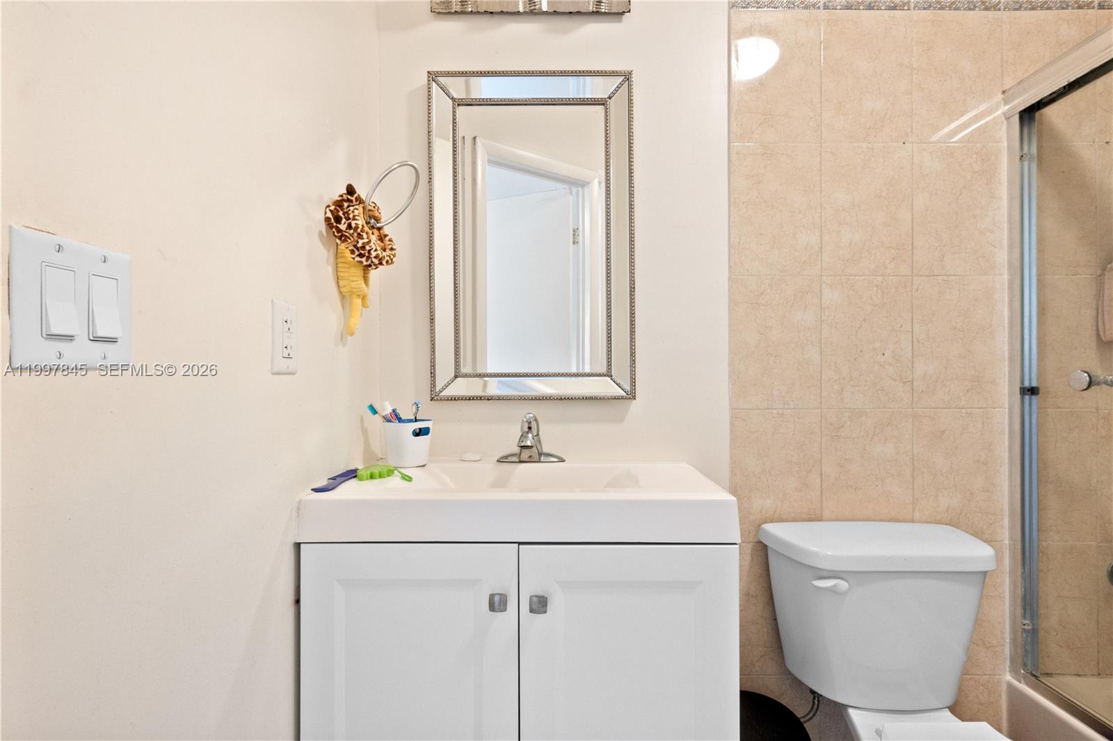6211 Southwest 138th Court, Unit B Miami, FL 33183 - Photo 10 of 24 a bathroom with a toilet sink and mirror