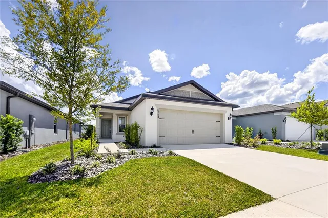 a front view of a house with a yard and garage