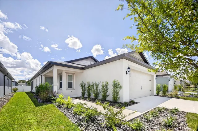 a front view of a house with a yard and a garden