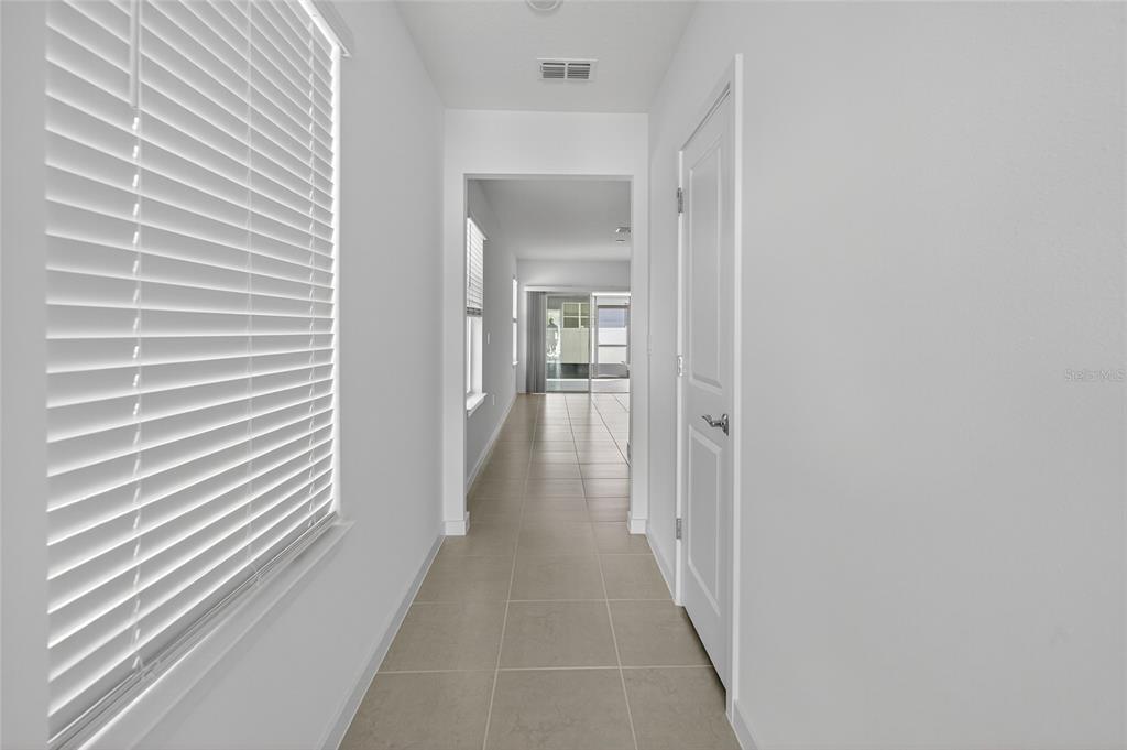 6784 Southwest 90th Loop Ocala, FL 34476 - Photo 4 of 11 a view of a hallway with wooden floor and a bathroom