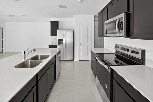 a kitchen with stainless steel appliances kitchen island a sink stove and refrigerator