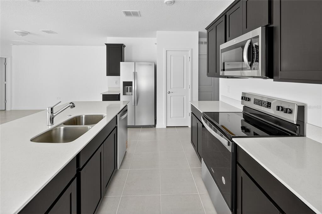 6784 Southwest 90th Loop Ocala, FL 34476 - Photo 6 of 11 a kitchen with stainless steel appliances kitchen island a sink stove and refrigerator