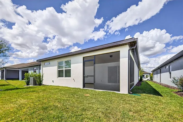 a view of a house with a big yard and a large tree