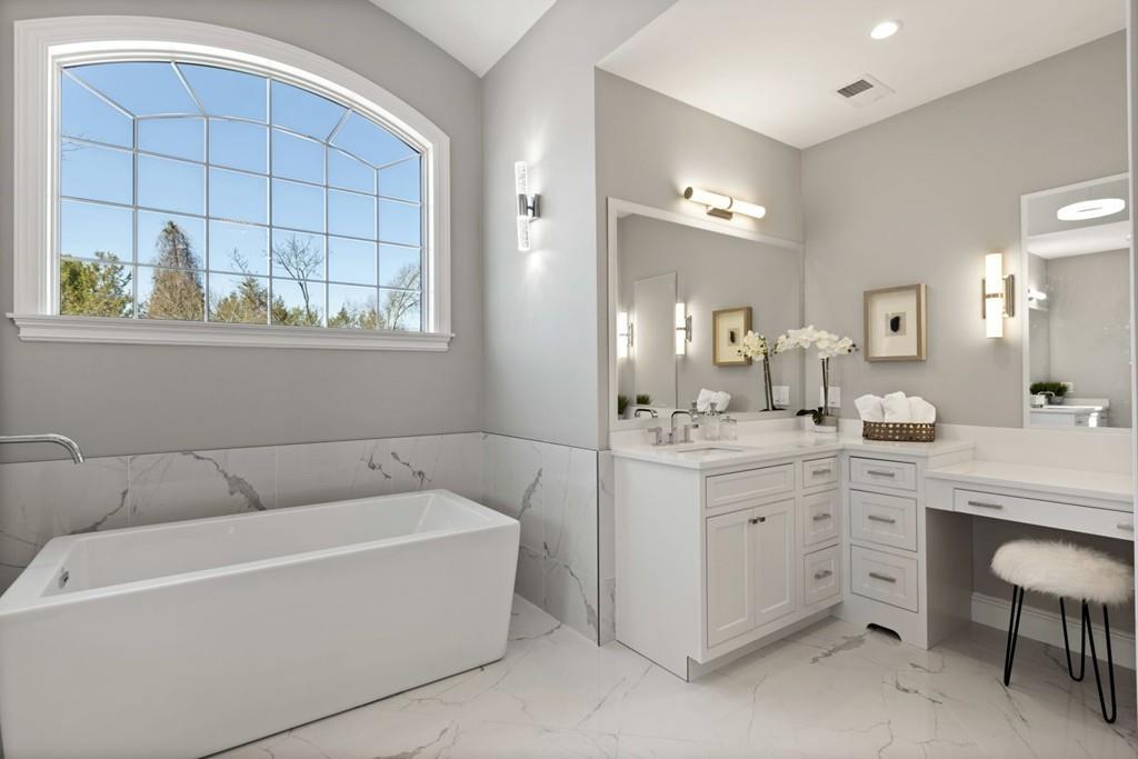 11 Fairhaven Road Newton, MA 02459 - Photo 31 of 40 a bathroom with a bathtub a double vanity sink a window and mirror