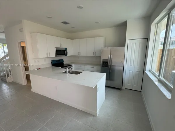 a kitchen with refrigerator and cabinets