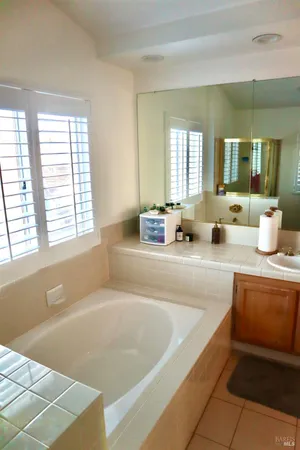 a bedroom with a bed a flat screen tv and a window