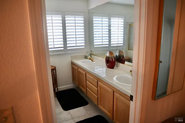 a view of brick house with a large window and potted plants
