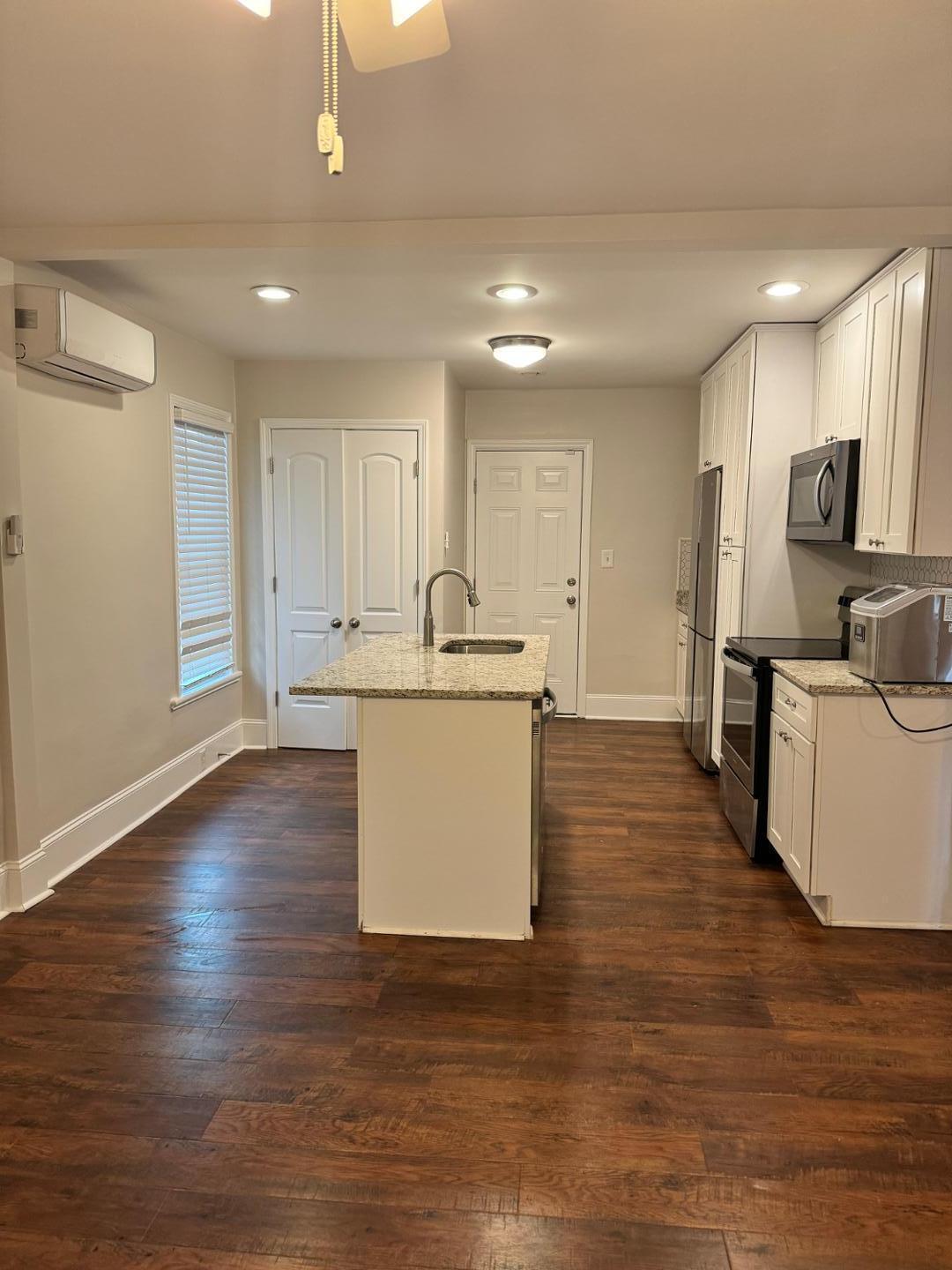 1218 Pender Street Raleigh, NC 27610 - Photo 12 of 21 a kitchen with kitchen island a sink stainless steel appliances and cabinets
