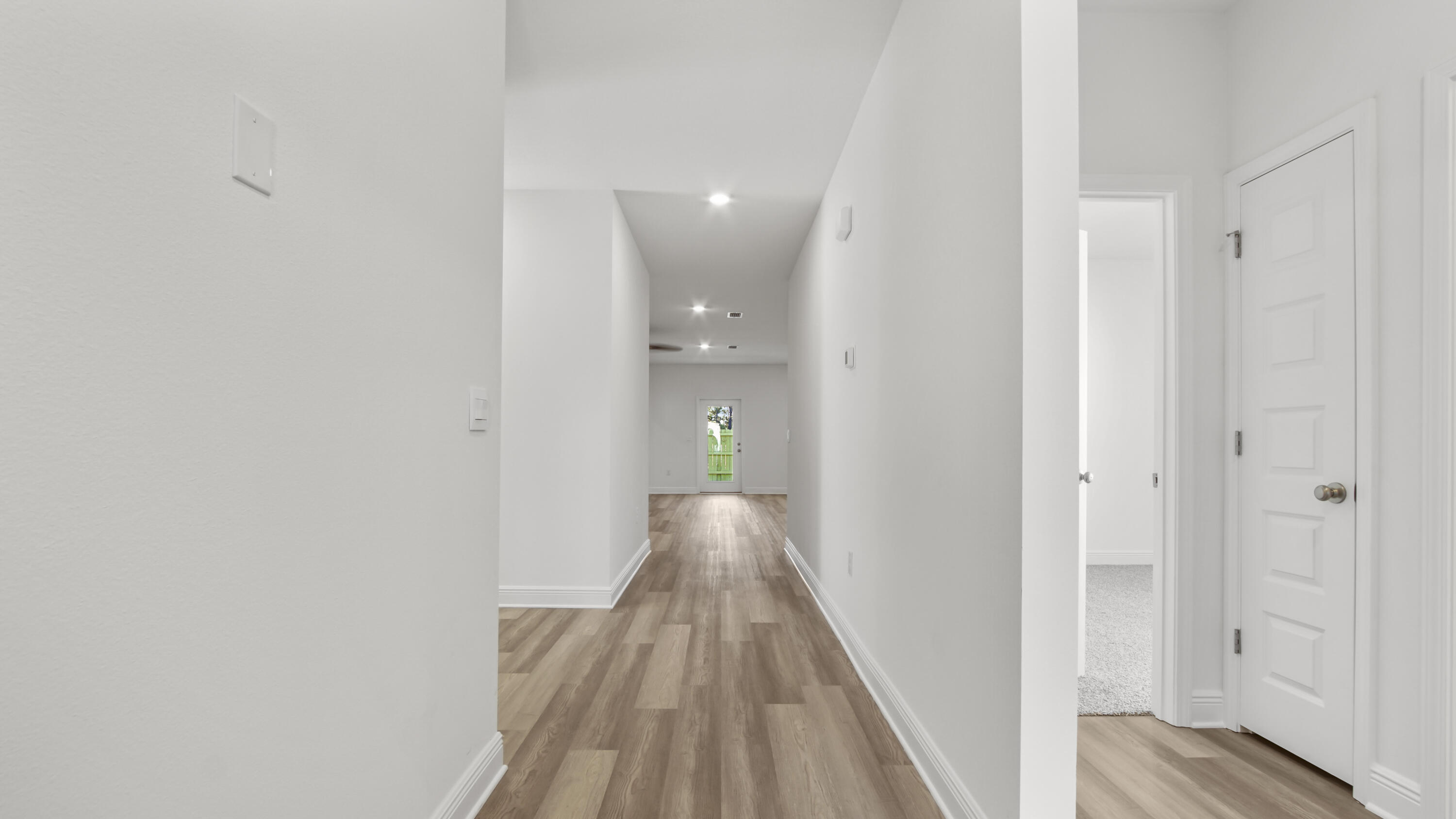 86 Grass Owl Loop Freeport, FL 32439 - Photo 3 of 34 a view of a hallway with wooden floor and a bathroom