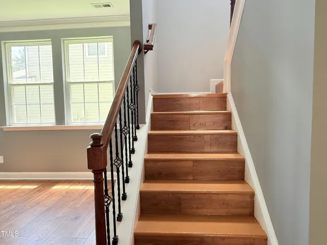 a kitchen with granite countertop wooden floors stainless steel appliances and a sink