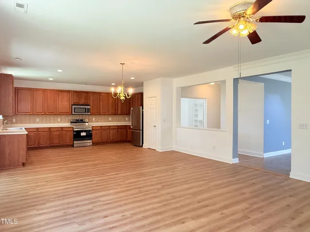 a kitchen with granite countertop a stove a sink and a microwave