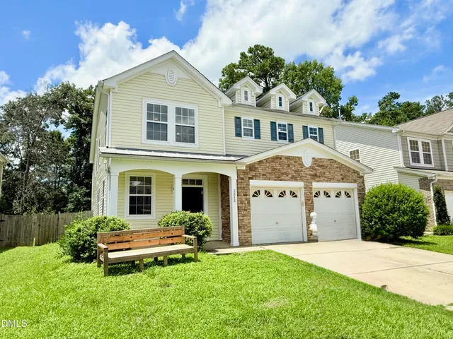 a front view of a house with a yard and garage