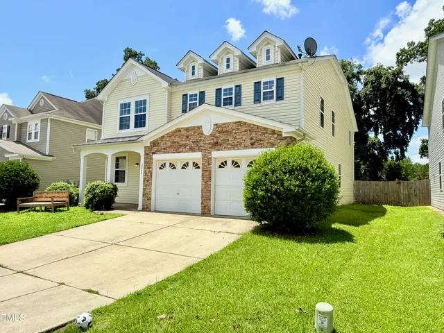 a front view of a house with a garden