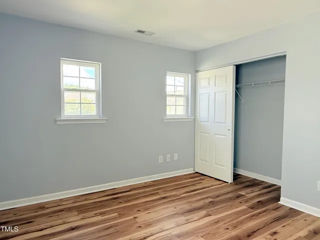 a view of empty room with wooden floor