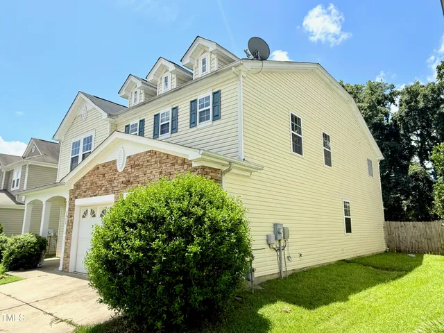 a view of a white house with a yard and plants