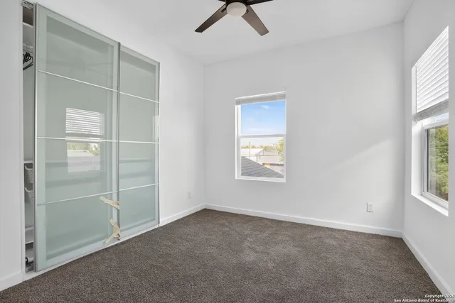 an empty room with windows and closet