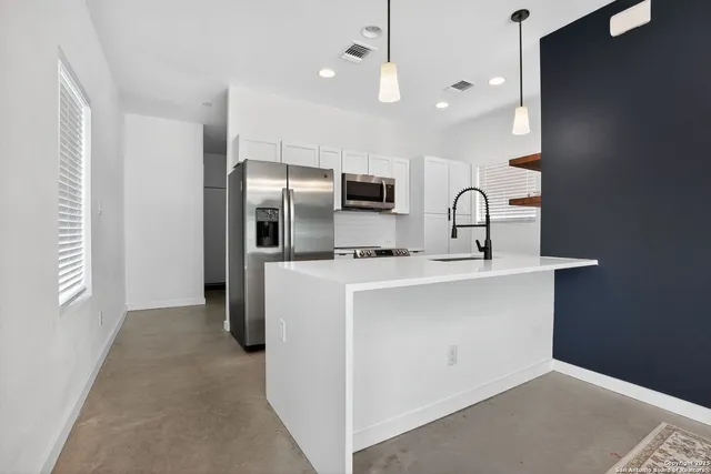 a kitchen with kitchen island a sink stainless steel appliances and window
