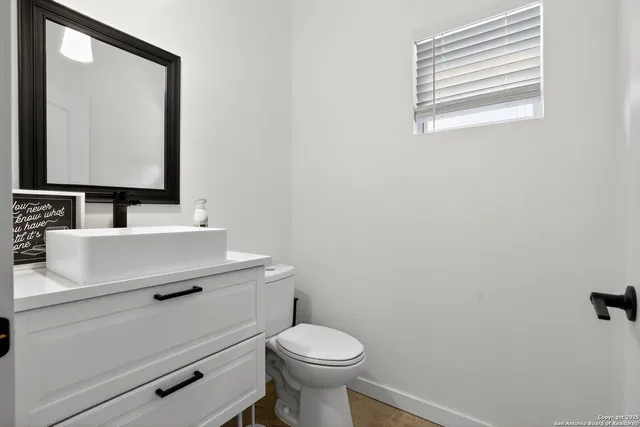 a bathroom with a sink a toilet and mirror