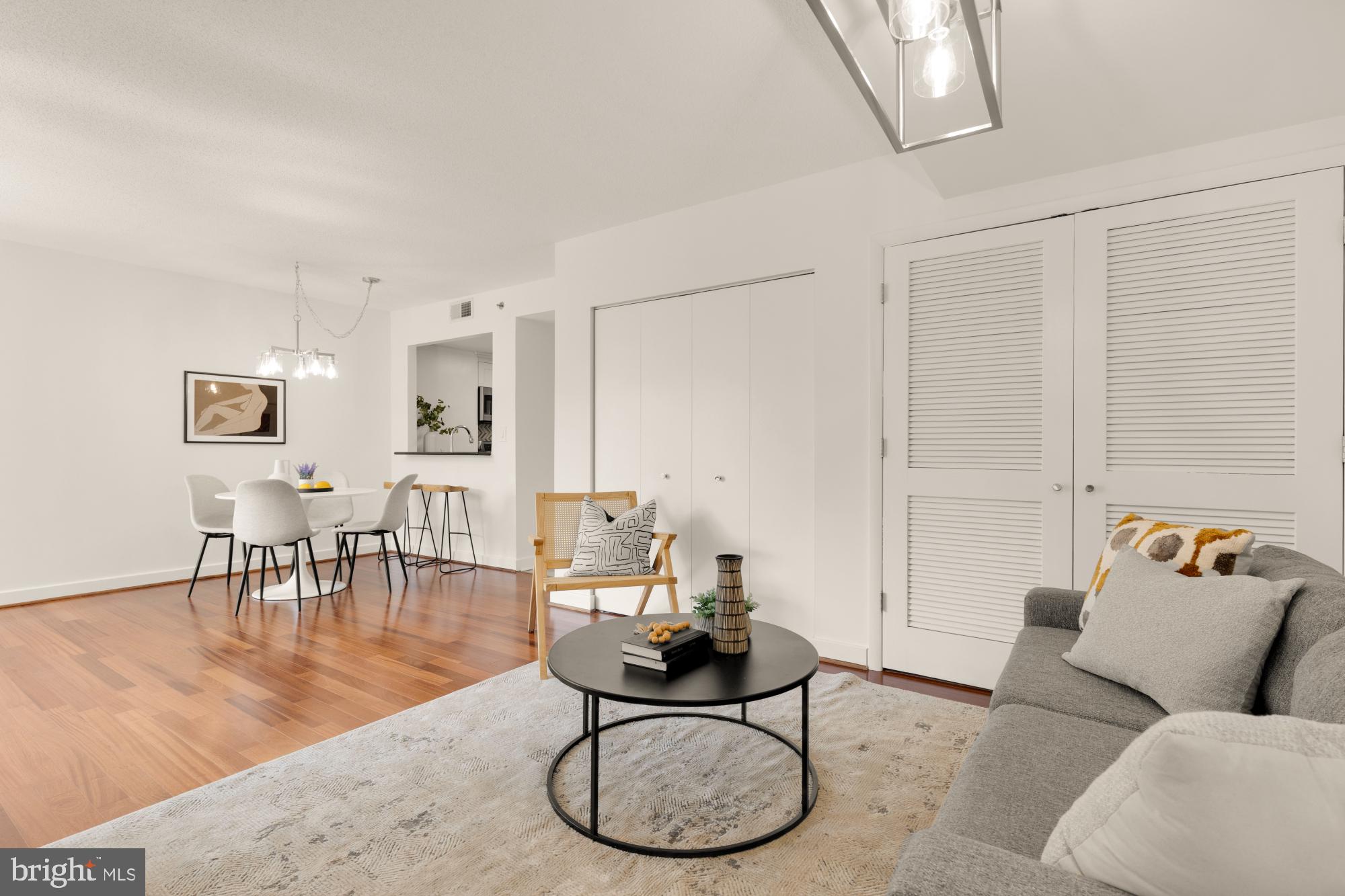 1150 K Street Northwest, Unit 1211 Washington, DC 20005 - Photo 12 of 29 a living room with furniture a dining table and a chandelier