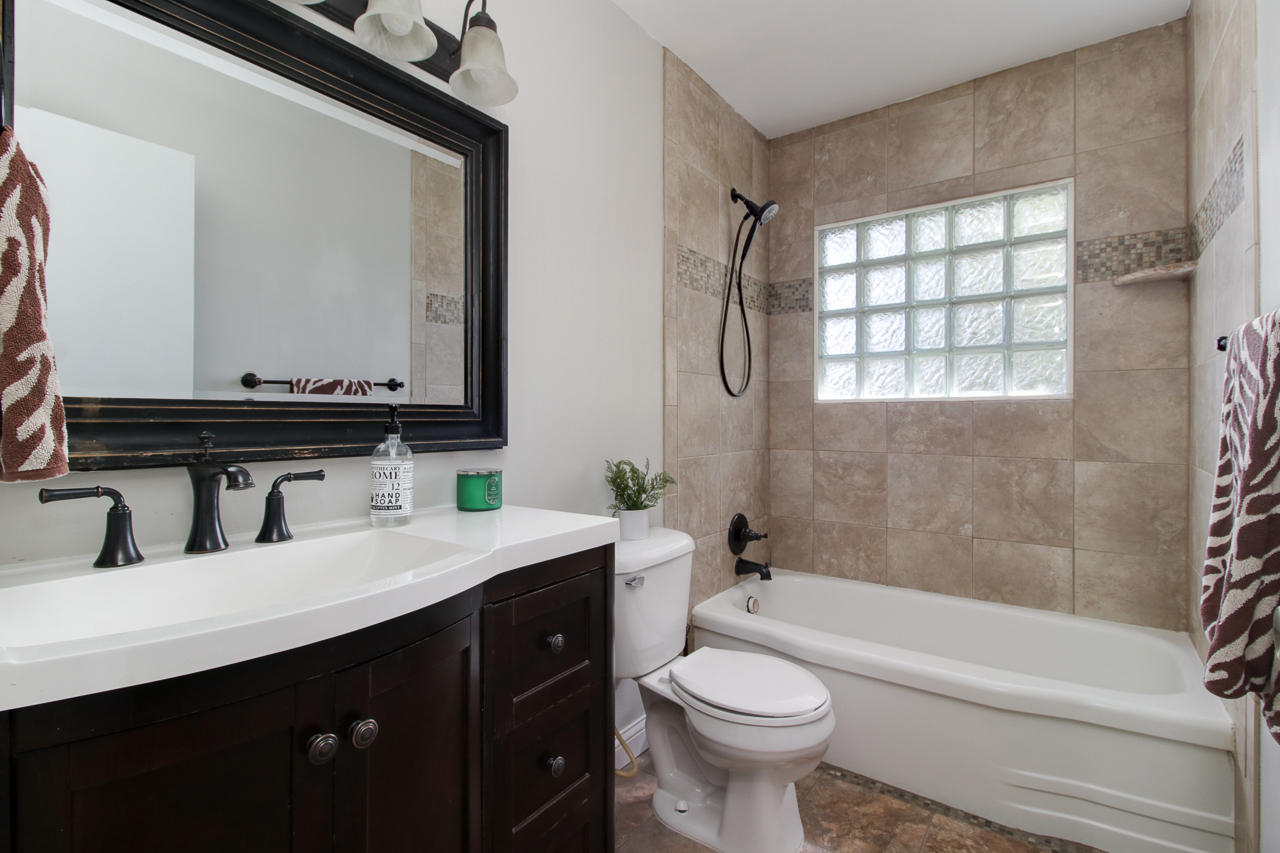 813 Parmon Road Bloomington, IL 61701 - Photo 11 of 23 a bathroom with a bathtub sink mirror vanity and toilet