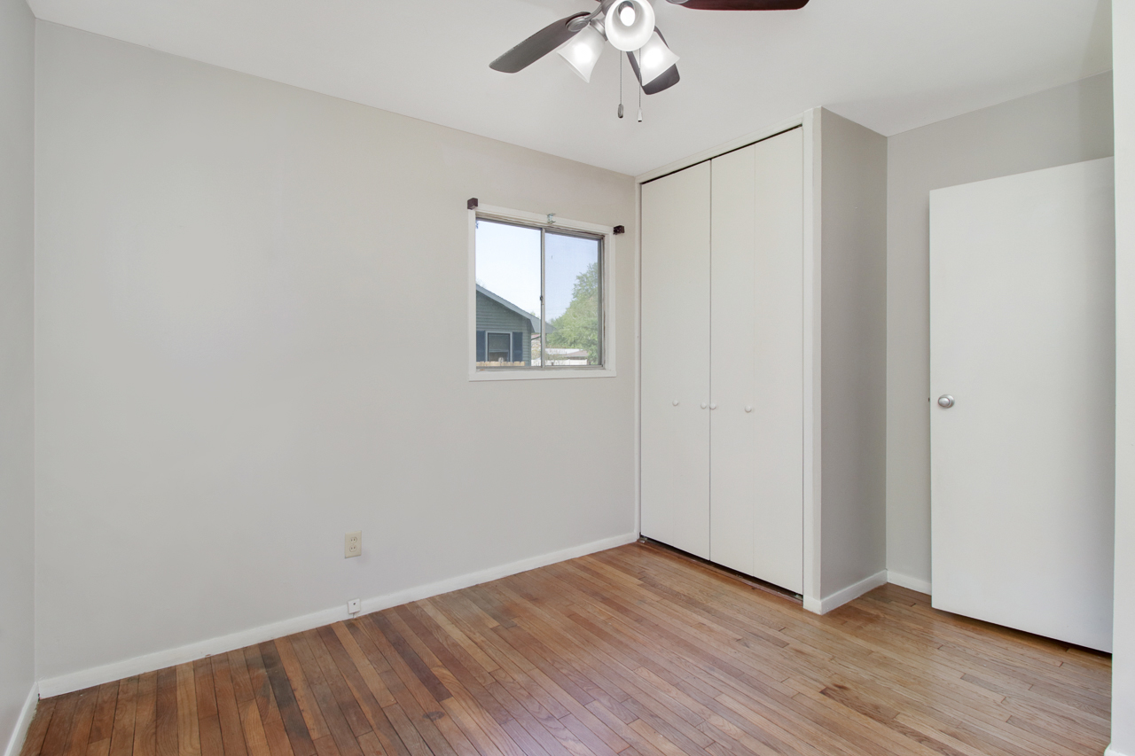 813 Parmon Road Bloomington, IL 61701 - Photo 14 of 23 an empty room with wooden floor chandelier fan and windows
