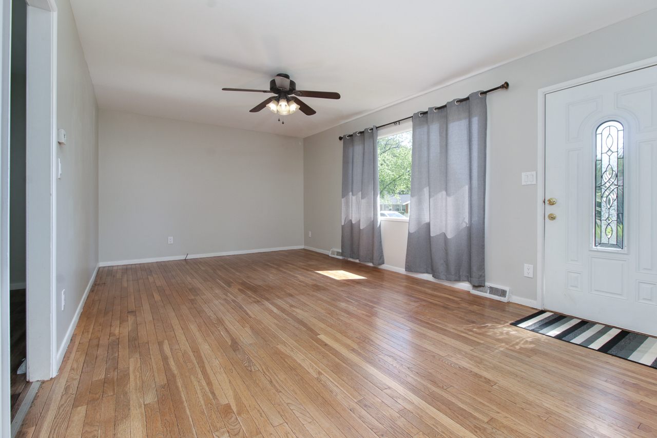 813 Parmon Road Bloomington, IL 61701 - Photo 4 of 23 a view of empty room with wooden floor and fan