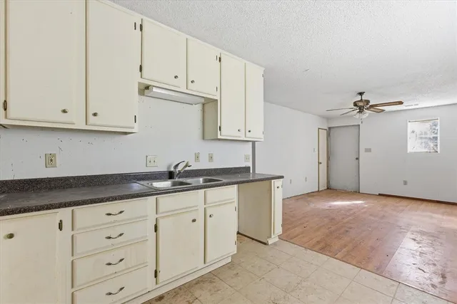 a kitchen with granite countertop white cabinets and sink