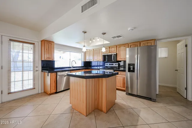 a kitchen with stainless steel appliances granite countertop a refrigerator a sink a stove a microwave and island