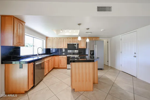 a kitchen with stainless steel appliances granite countertop a refrigerator and a stove top oven