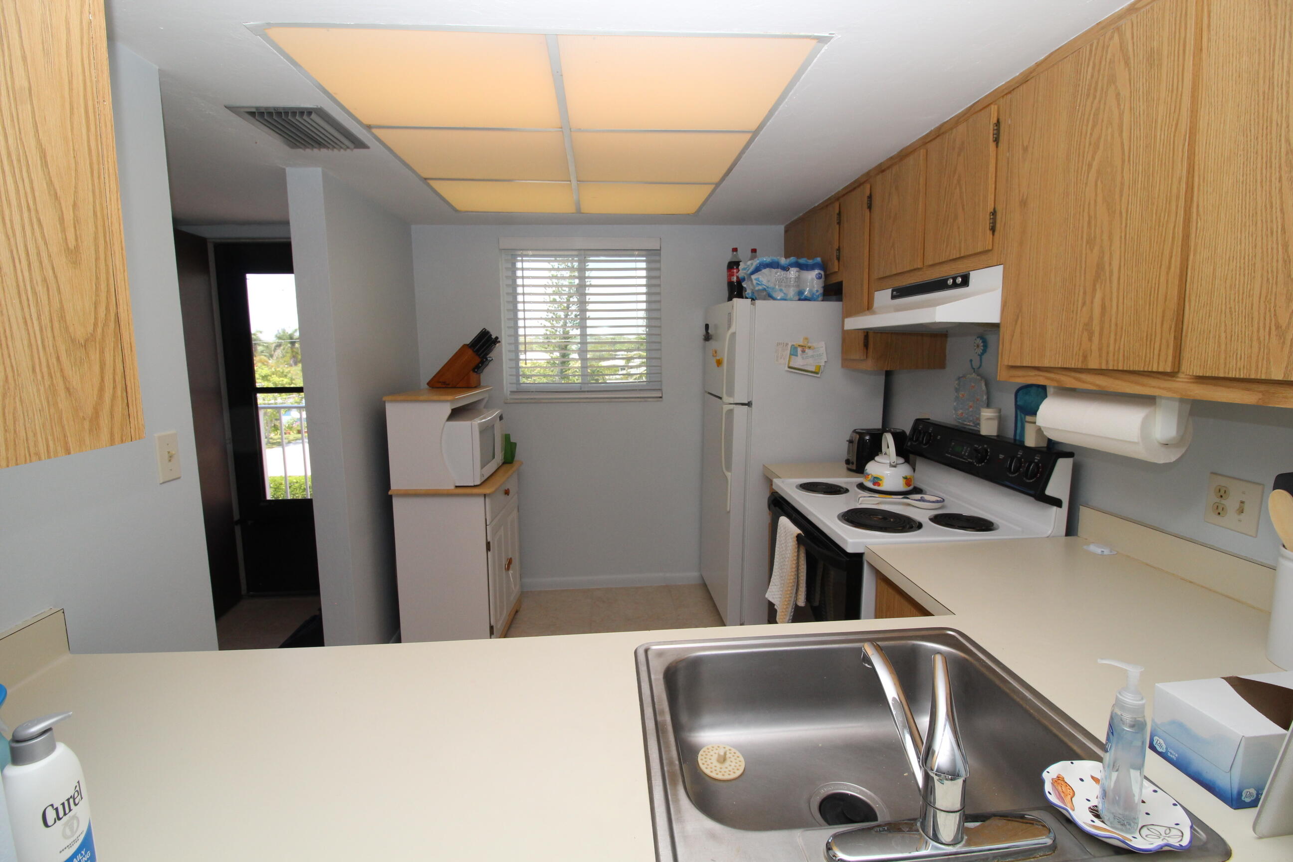 1024 Manatee Naples, Unit C301 Naples, FL 34114 - Photo 6 of 23 a kitchen with a sink a stove and refrigerator