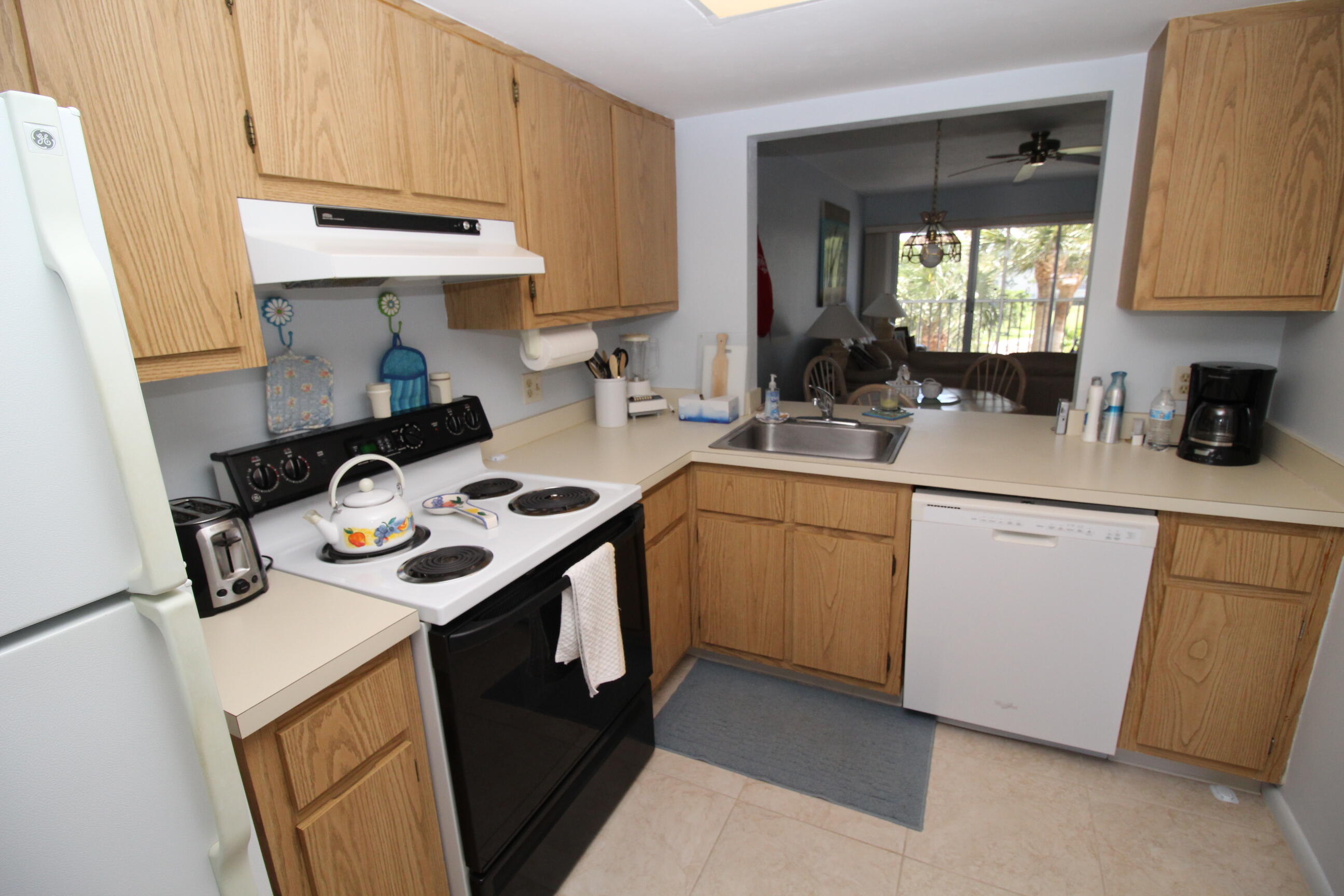 1024 Manatee Naples, Unit C301 Naples, FL 34114 - Photo 7 of 23 a kitchen with stainless steel appliances granite countertop a sink stove and cabinets
