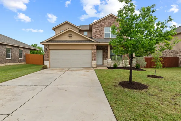 a front view of a house with a yard and trees