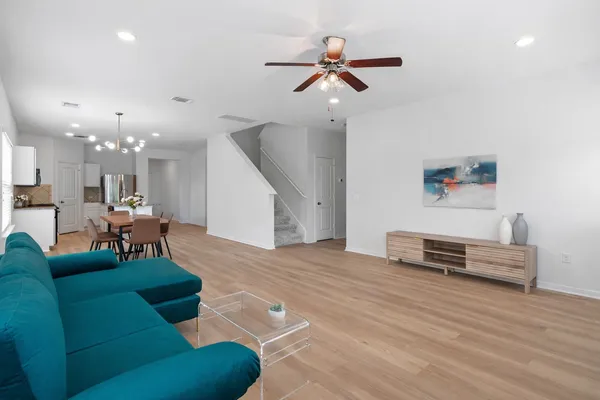 a living room with furniture and a wooden floor