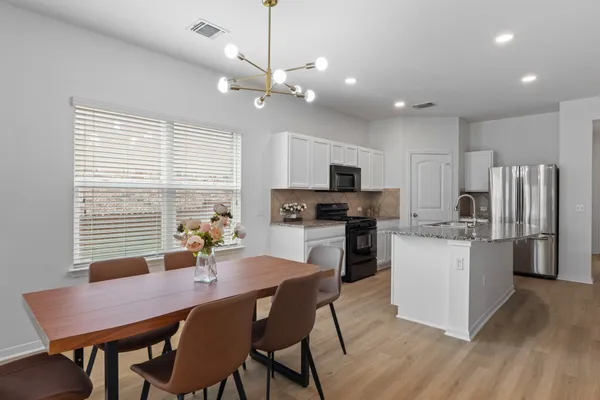 a kitchen with kitchen island a dining table and chairs