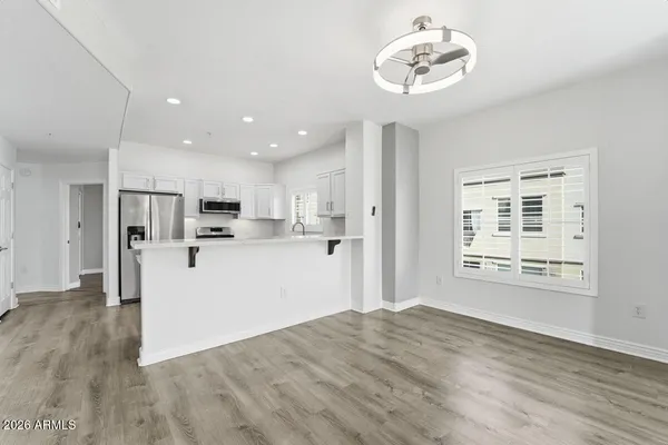 a view of a kitchen with wooden floor and a refrigerator