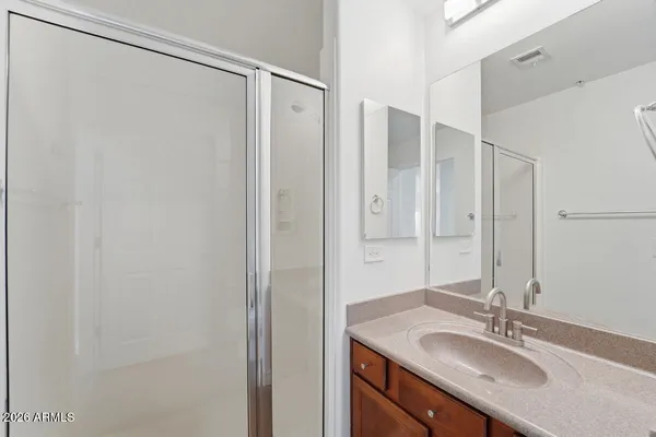 a bathroom with a granite countertop sink shower and a mirror