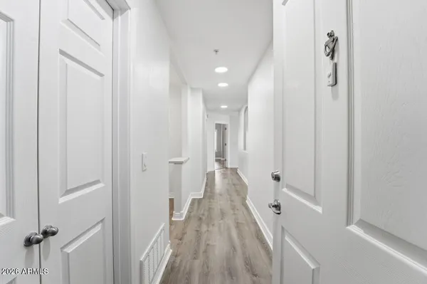 a view of a hallway with wooden floor and staircase